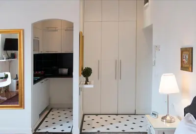 a living room with a refrigerator and a table with a lamp at Belle Apartments - Obilicev Venac in Belgrade