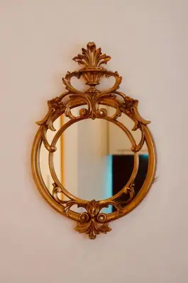 an ornate gold mirror hanging on a wall at Belle Apartments - Obilicev Venac in Belgrade