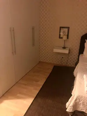 a bedroom with a bed and a shelf with a lamp at Belle Apartments-Elegance Apartments in Belgrade