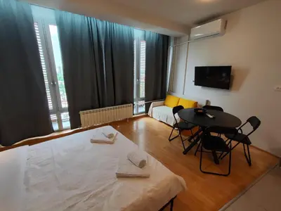 a living room with a table and chairs and a couch at Belle Apartments-Elegance Apartments in Belgrade