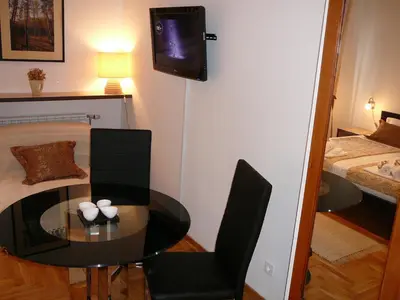 a small room with a table and a tv on a wall at Belle Apartments - Luxury Apartments in Belgrade