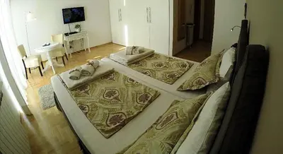a bedroom with two beds with pillows and a table at Belle Apartments - Luxury Apartments in Belgrade
