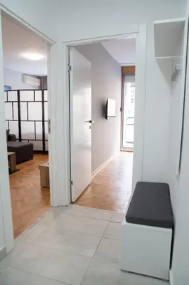 a living room with a bench and a door at Tommy Apartment in Belgrade