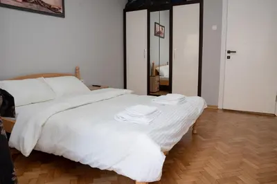 a bedroom with a white bed with two towels on it at Tommy Apartment in Belgrade