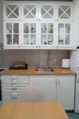 a kitchen with white cabinets and a wooden counter top at Tommy Apartment in Belgrade