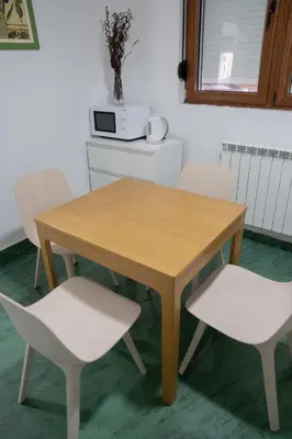 a wooden table with two white chairs around it at Tommy Apartment in Belgrade
