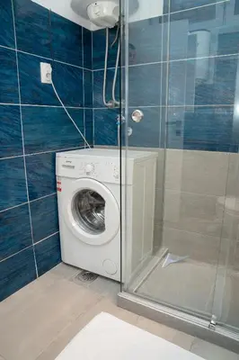 a washing machine in a bathroom with a shower at Tommy Apartment in Belgrade