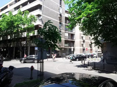 a city street with cars parked in front of a building at Downtown Belgrade Apartments - CHERRY in Belgrade