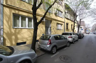 a row of parked cars parked next to a building at Sneki Apartment in Belgrade