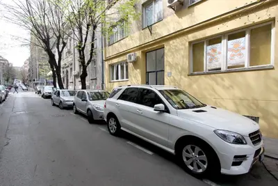 a row of cars parked on the side of a street at Sneki Apartment in Belgrade