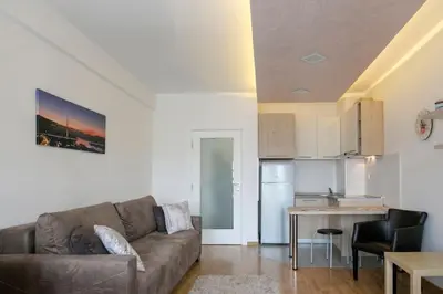 a living room with a couch and a kitchen at Apartman Cezar in Belgrade
