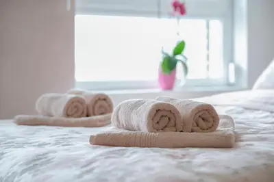 three rolled towels sitting on top of a bed at Apartman Cezar in Belgrade
