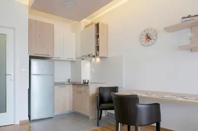 a kitchen with a table and chairs and a refrigerator at Apartman Cezar in Belgrade