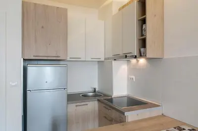 a white kitchen with a refrigerator and a sink at Apartman Cezar in Belgrade