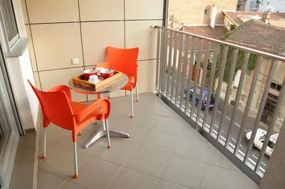 two orange chairs and a table on a balcony at Shining in Belgrade