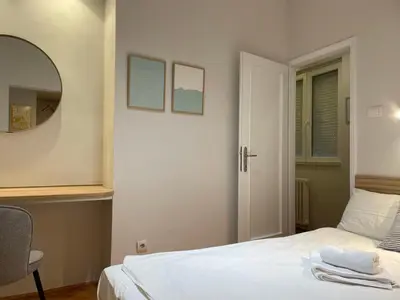 a bedroom with a white bed and a mirror at City Break Apartments Klishe Zen in Belgrade