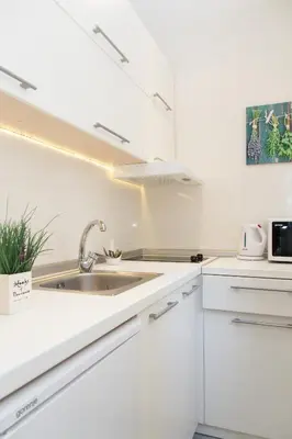 a kitchen with white cabinets and a sink at City Break Apartments Klishe Zen in Belgrade