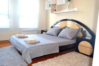 a bedroom with a large bed with an iron headboard at Clean&Cozy Apartments Novi Beograd in Belgrade