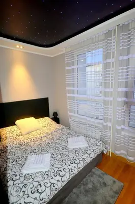 a bedroom with a bed and a large window at Clean&Cozy Apartments Novi Beograd in Belgrade