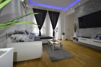 a living room with a white couch and a tv at Clean&Cozy Apartments Novi Beograd in Belgrade