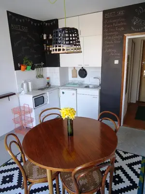 a kitchen with a wooden table with chairs and a kitchen with a table at Apartment Downtown Atelje in Belgrade