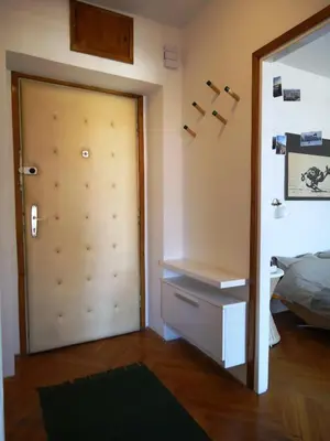 a bedroom with a door and a bed and a mirror at Apartment Downtown Atelje in Belgrade