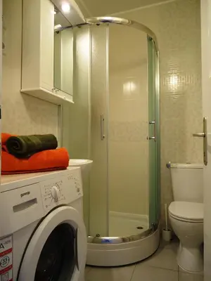 a bathroom with a shower and a washing machine at Apartment Downtown Atelje in Belgrade