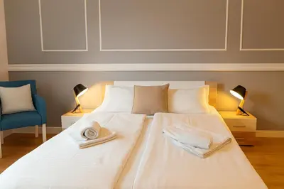 a bedroom with a white bed with towels on it at City Break Apartments - City Zen in Belgrade