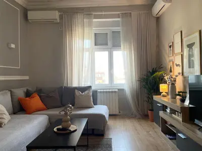 a living room with a couch and a window at City Break Apartments - City Zen in Belgrade