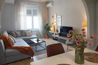 a living room with a couch and a tv at City Break Apartments - City Zen in Belgrade