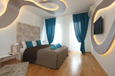 a bedroom with a bed with blue pillows at Riviera 2 New Belgrade studio apartment, parking 5 evra dan in Belgrade