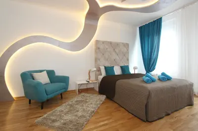 a bedroom with a bed and a blue chair at Riviera 2 New Belgrade studio apartment, parking 5 evra dan in Belgrade