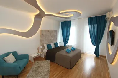 a bedroom with a bed and a blue chair at Riviera 2 New Belgrade studio apartment, parking 5 evra dan in Belgrade