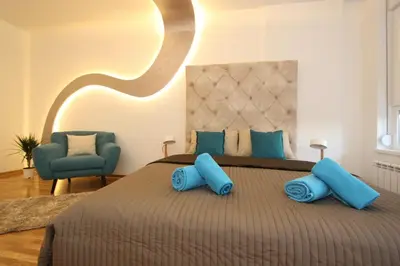a bedroom with a large bed with blue pillows at Riviera New Belgrade apartment, parking 5 eur per day in Belgrade