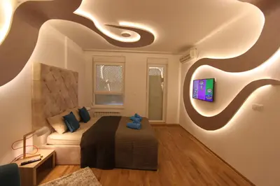 a bedroom with a bed and a tv on a wall at Riviera New Belgrade apartment, parking 5 eur per day in Belgrade