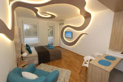 a bedroom with a bed and a blue chair at Riviera New Belgrade apartment, parking 5 eur per day in Belgrade