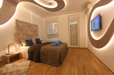 a bedroom with a bed and a flat screen tv at Riviera New Belgrade apartment, parking 5 eur per day in Belgrade