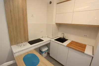 a small kitchen with white cabinets and a sink at Riviera New Belgrade apartment, parking 5 eur per day in Belgrade