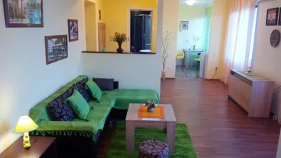 a living room with a green couch and a table at Balkan-inn Skadarlija 2 apartment in Belgrade