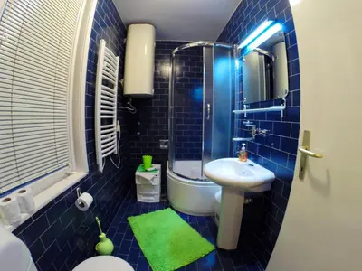 a blue tiled bathroom with a sink and a toilet at Balkan-inn Skadarlija 2 apartment in Belgrade