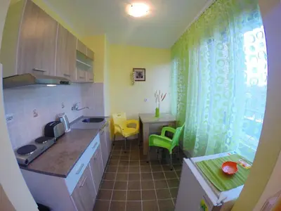 a kitchen with a sink and a table with yellow chairs at Balkan-inn Skadarlija 2 apartment in Belgrade