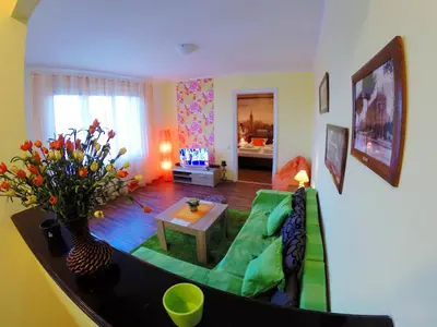 a living room with a green couch and a table at Balkan-inn Skadarlija 2 apartment in Belgrade