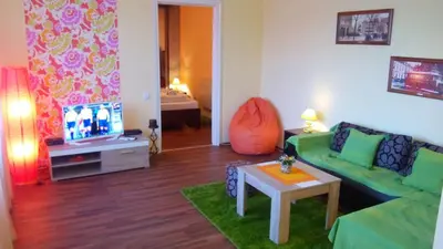 a living room with a green couch and a tv at Balkan-inn Skadarlija 2 apartment in Belgrade