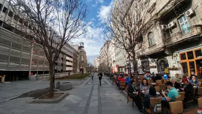 a group of people sitting in chairs on a city street at Balkan-inn Studio Centar apartment in Belgrade