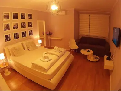 a bedroom with a large bed and a couch at Balkan-inn Parlament Lux apartment in Belgrade
