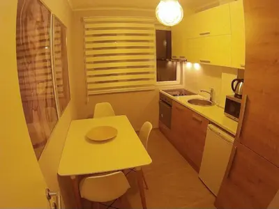 a small kitchen with a small yellow table and chairs at Balkan-inn Parlament Lux apartment in Belgrade