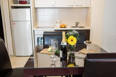 a kitchen with a table with wine glasses and flowers at Balkan-inn Parlament apartment in Belgrade