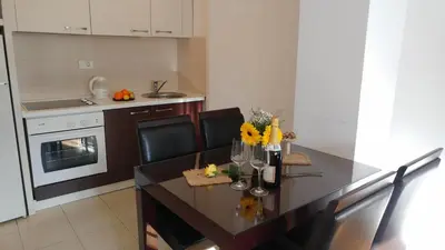 a kitchen with a dining room table with flowers on it at Balkan-inn Parlament apartment in Belgrade