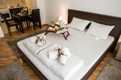 a large white bed with towels and a table at Balkan-inn Parlament apartment in Belgrade