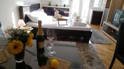 a living room with a couch and a table with wine glasses at Balkan-inn Parlament apartment in Belgrade